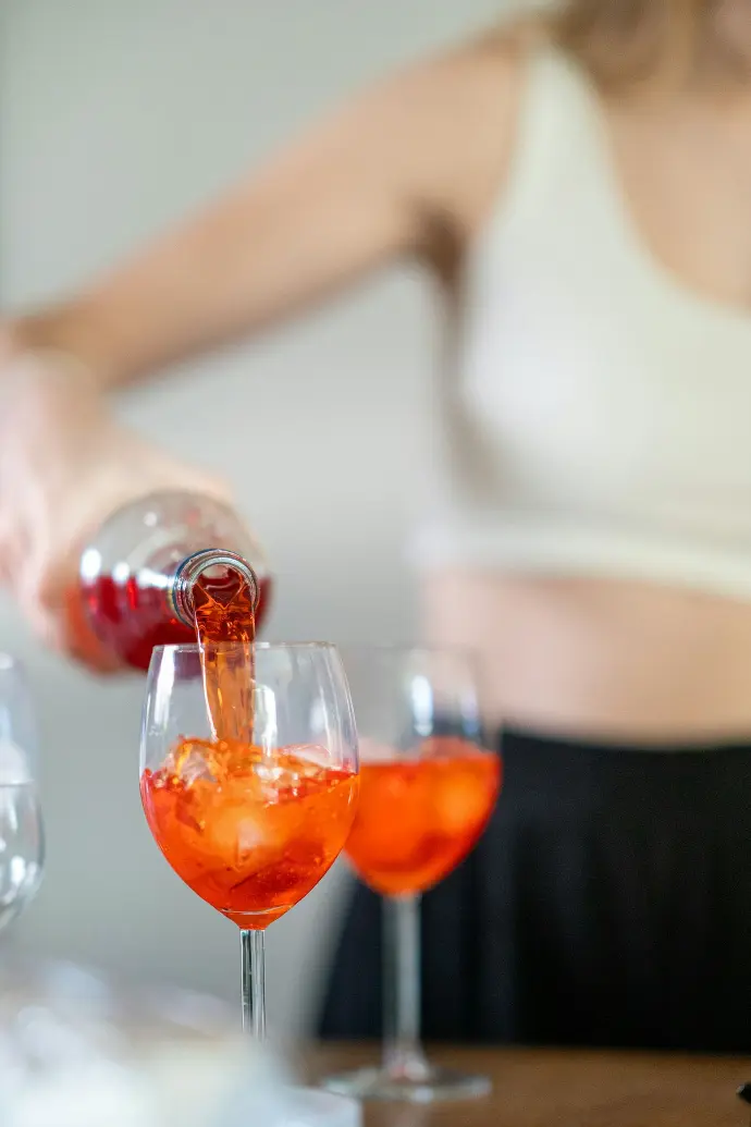 a woman pouring a glass of red wine