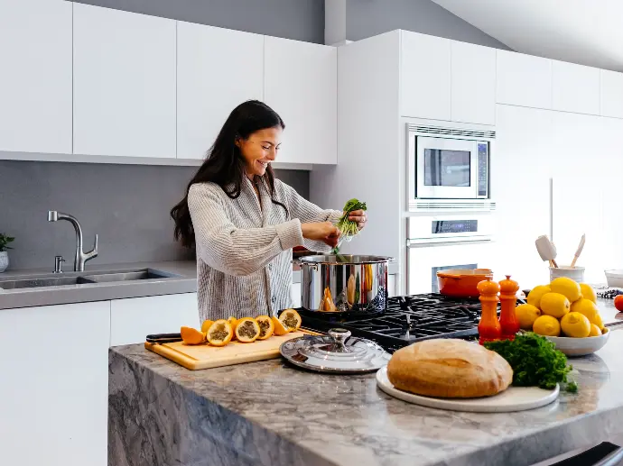 woman smiling while cooking